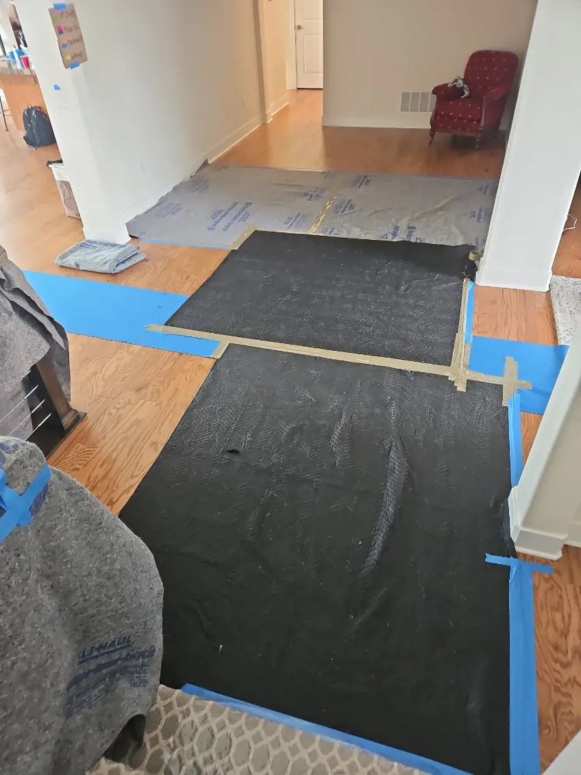 Floor runners and taped protective coverings across a doorway and hall
