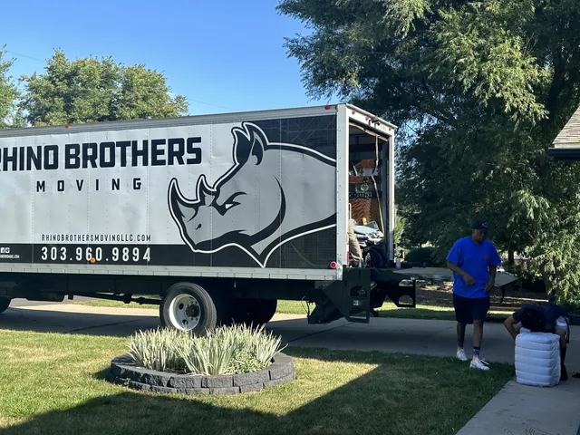 Rhino Brothers moving truck parked outside a home with a mover nearby