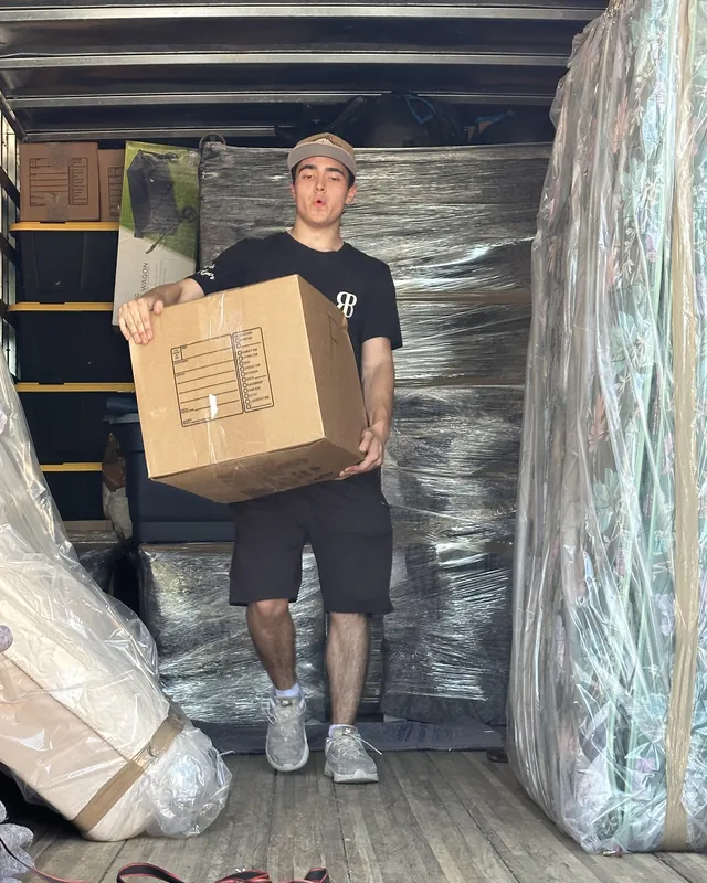 A Rhino Brothers mover carrying a box inside a carefully loaded truck